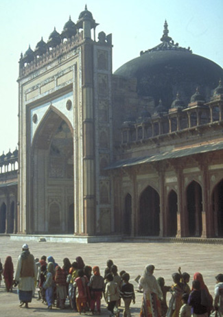 Children leaving a Qur'an class file across the courtyard of Dargah Mosque, built by the Moghul emperor Akbar at his short-lived capital of Fatehpur Sikri. 