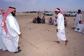 “Dirt time” for tracker testing: Mohammed Ali al-Amrah al-Murri, left, examines the footprints of 20 “suspects” one at a time, matching them in his mind with the tracks of six men who passed over the same ground a few minutes earlier.