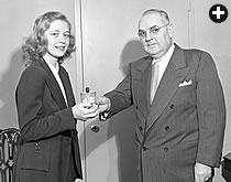 In this photo published in January 1950—the date of the first issue to carry the name Aramco World—Anne Trust receives her $50 prize from Aramco president William F. Moore.