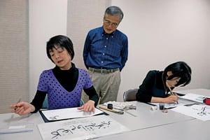 Koichi Yamaoka, who took early retirement to devote himself to calligraphy instruction, offers guidance to students Tomoko Fujii and Keiko Narita. “When I teach Arabic calligraphy, I explain the background of the culture,” he says. 