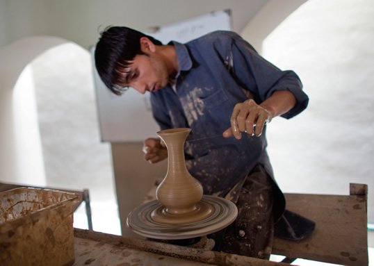 ヒンドゥークシュ山脈で採掘した粘土から一般に販売する花瓶を作成する陶芸の学生。