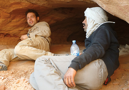 Ibrahim, at left, and an assistant rest at a dig site on “The River of Giants.” 