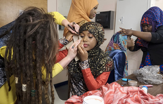 Wearing Hassan’s designs, models prep for the runway. “I decided to create fashions appropriate to my culture and to my beliefs,” Hassan says, “but also unique and sophisticated‚ so that both Muslim and non-Muslim women would want to wear it.”