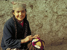 An Uygur girl embroiders a traditional cap. 