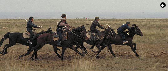 Western tourists and Kazak horsemen represent contrasting lifestyles.