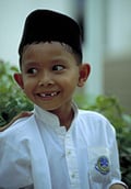 A Malaysian boy wearing the black songkok headgear of many Southeast Asian Muslims. 