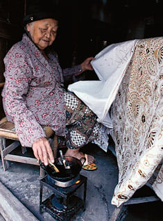 A master at batik tulis sarongs, Ibu Djogo Pertiwi, 96, applies wax using a pencil-like canting.