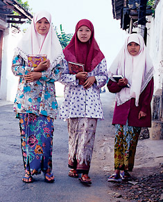 Schoolgirls in the town of Kudus walk home wearing machine-printed batik sarongs. 