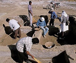 Madjidzadeh, in white hat at center, examines objects found near Konar Sandal B in a trench overseen by Romain Pigeaud of the Paris National Museum of Natural History.
