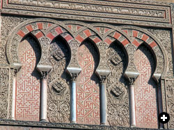 Above the western portal of Córdoba’s Great Mosque, a decorative panel displays interlaced arches, stucco elaborately carved in vegetative and floral patterns, and a pious inscription.