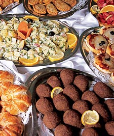 A wedding buffet is often where national cuisines meet. Here, kubbah and sambusak, both fried, dough-wrapped meat hors d’oeuvres, share a table with small pizzas.