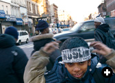 Outside the mosque, a boy ties on a headband that reads “Muslim: Total Submission.” 