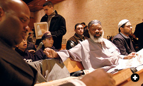Imam Siraj Wahhaj speaks with city council candidate Naquan Muhammad (far left).