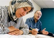 Sahar Al-Mosawi looks over a practice test with ACCESS bilingual counselor Adnan Almurani.