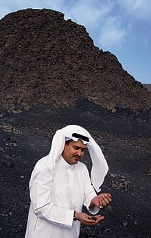 Maher Idris, assistant president of the SGS, holds loose volcanic cinders. Along with monitoring of "geohazards"—earthquakes are riskier than volcanos, he points out—the job of the SHS is to "effectively balance exploitation with the need for geo-conservation."
