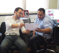 Designers Hasaan Kanaan and Mohamed Azab confer on a layout. 