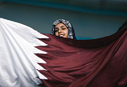 A Qatari fan waves her country’s flag during the swimming heats.