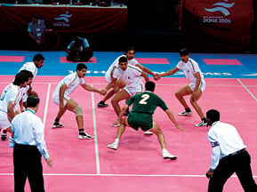 Pakistan’s Muhammad Akram tries to tag one of his Indian opponents during the kabaddi group match, but India won 31–20 to take the gold.