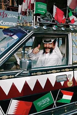 Showing his enthusiasm with an art car, a Qatari man gives the Asian Games a thumbs-up.