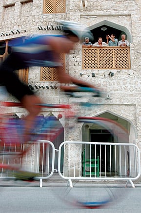 Spectators in the Qatari town of Souqs view competitors during the cycling portion of the men’s triathlon.
