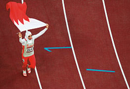 Bahrain’s Ruqaya Al-Ghasara waves a Bahraini flag after winning a gold medal in the women’s 200-meter race.
