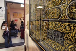 A tapestry embroidered with verses from the Qur’an hangs on the wall outside the examination rooms at the clinic.