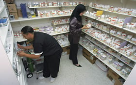 Pharmacy technician Rafael Gomez and volunteer doctor Naima Frewam, who was born in Libya, work in the pantry that stocks donated medicine.