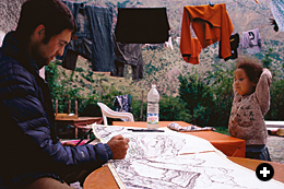 Sa‘id and Fatima Mas’udi’s daughter, Rashida, watches climber Renan Öztürk as he sketches the landscape of her village from the guesthouse. She started school in Taghia in 2006.