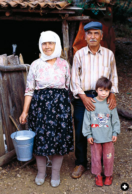Emine and Hulise Kazık with a grandchild and a pail of fresh goat’s milk.