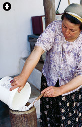 Sulfer Kazık pouring day-old yogurt into a traditional wooden hand churn, or kovan