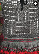 The trailing back panel of this headdress from the Bani Saad tribe, in the area around Taif, is heavily embroidered with lead beads in geometric designs and finished with an edge of red tassels.