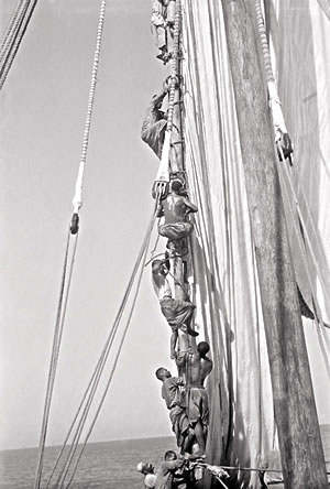 Kuwaiti sailors climb without footropes as they work on the green lateen yard, or spar.