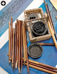 An ink pot and pens cut from bamboo lie on top of a work in progress in the studio of Japan’s leading master calligrapher of Arabic, Fuad Kouichi Honda.