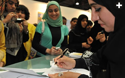 At the fair’s Book-Signing Corner, author Mahra Muhammad Bani Yas signs for young fans