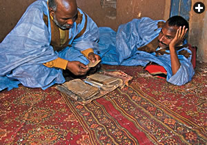 Soueid Ould Mohamed Bouyatou, left, and Limam Ould Abdel Mu’min show manuscripts from their archive, one of some 20 archives and libraries in the oasis with writings that date to as early as the 12th century. 