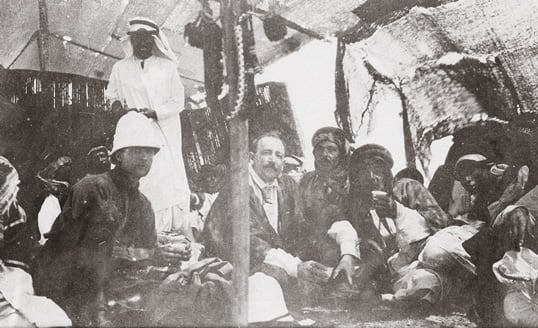 In the camp of the Fedaan tribe of the Anazeh, Davenport (center) felt so at ease that he was moved to declare that he had known from childhood that he was destined to become a member of the tribe. Hanging from the tent pole is the halter of a war mare, which is a symbol of welcome. 