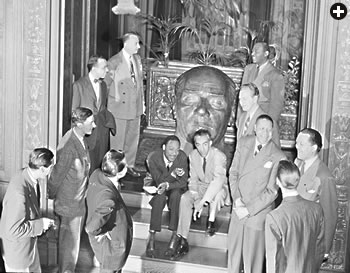 In the 1940’s, Ertegun often invited black and white musicians to mingle and jam together at the embassy. Here a group gathers around a bust of Kemal Atatürk, founder of the Turkish Republic. In 1947, Ertegun founded Atlantic Records.