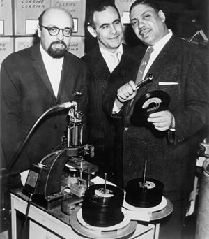Ertegun and Atlantic Records partner Jerry Wexler—who coined the term “rhythm and blues”—pose with musician Big Joe Turner in 1956 to mark the pressing of “Corinne, Corrina.”