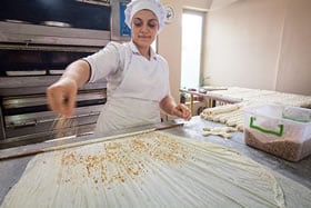 Pastry chefs in shops like Dila’s in Trabzon, top, use hundreds of kilograms of hazelnuts each week, which they scatter handful by handful, roll in thin dough, slice, sweeten and bake to make local dessert favorites.