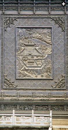 A bas-relief fresco depicts the traditional central Chinese walled building complex.  