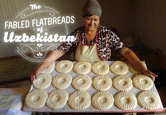 The Fabled Flatbreads of Uzbekistan - Written and photographed by Eric Hansen - Baker's assistant Gauhjaroy Kiyikiboyeva displays a tray of Tashkent-style non, stamped, oiled and ready for the tandoor oven.