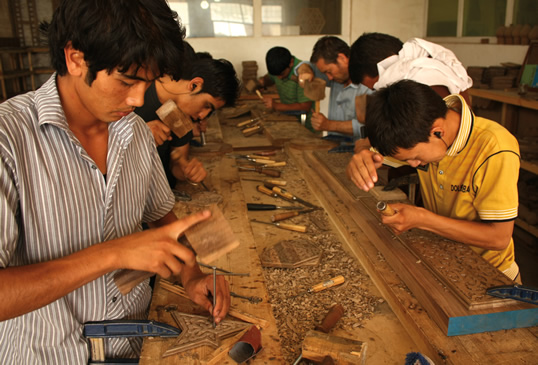 Hoy en día, sus estudiantes (abajo) encabezan un proyecto en su estudio en Kabul.