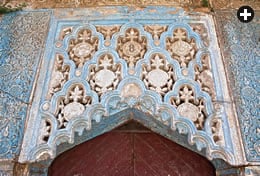 Sete medalhões, emoldurados por motivos florais e de concha, decoram um painel esculpido e pintado sobre uma porta. Os medalhões dos painéis laterais dizem “[não há] nenhum vencedor além de Deus”.